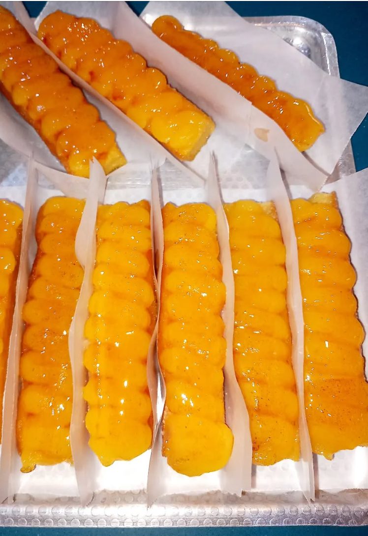 Fileres de borratxos daurats i brillants, col·locats en una safata amb paper de forn