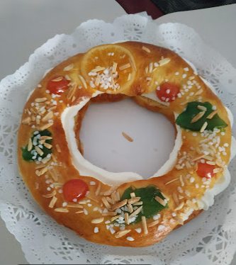 Tortell de Reis decorat amb fruita confitada i ametlla laminada, sobre una blonda de paper